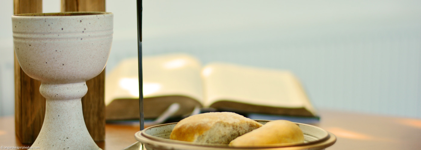 Abendmahlsgeschirr auf einem Altar mit Kreuz