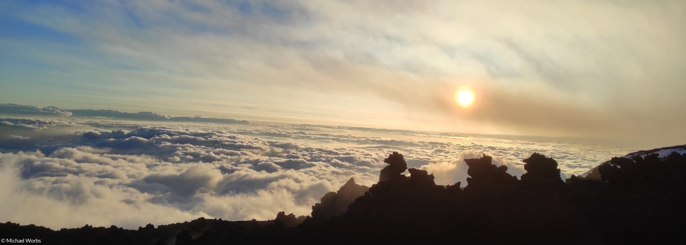 Symbolbild "Sehnsucht": Sonnenaufgang in den Bergen über den den Wolken